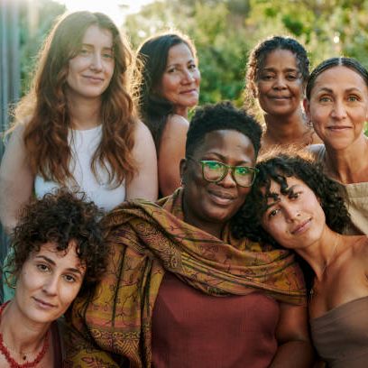 Womens circle A diverse group of eight women with varying expressions and hairstyles, outdoors.