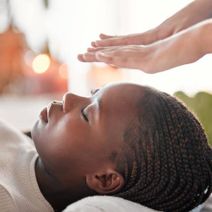 Usui Shiki Ryoho Reiki Training A person receiving healing touch with a serene expression, candles softly glowing in the background.